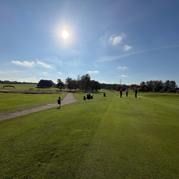 golfers from a distance with blue skies